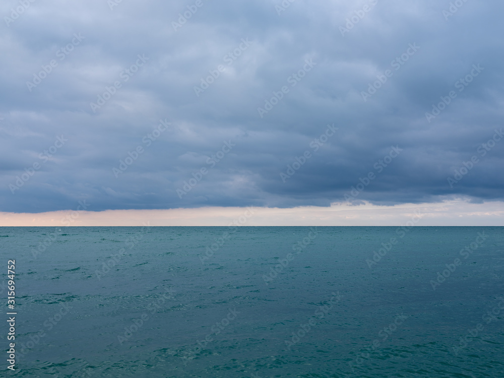 blue sea and cloudy sky over it