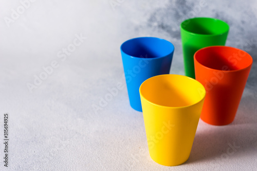 group color plastic cups on gray stone background plastic waste
