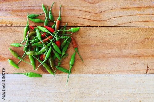 A pile of fresh chilli on wooden background for food ingredients and cooking concept