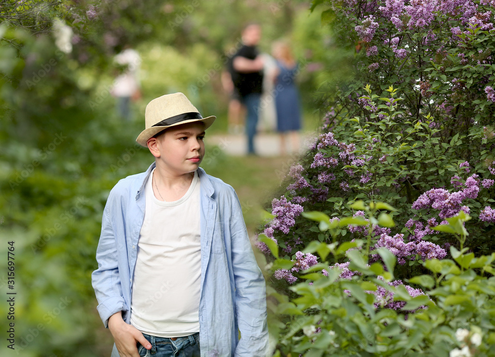 a boy in a hat walks in the spring botanical garden where flowers bloom