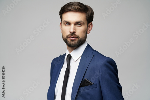 studio photo of young handsome stylish businessman wearing suit