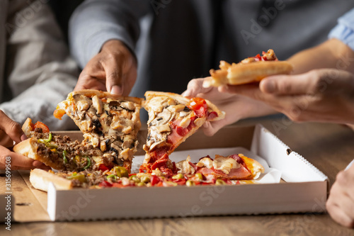 Close up of multiethnic friends share delicious pizza