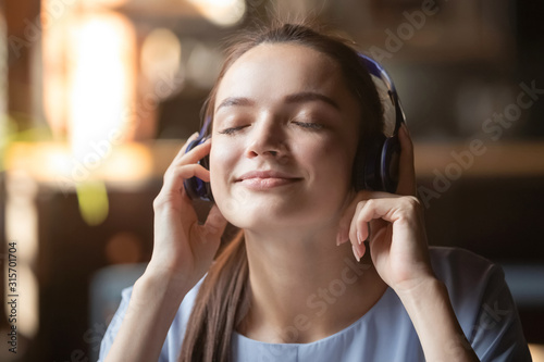 Happy girl enjoy music in modern Bluetooth headphones