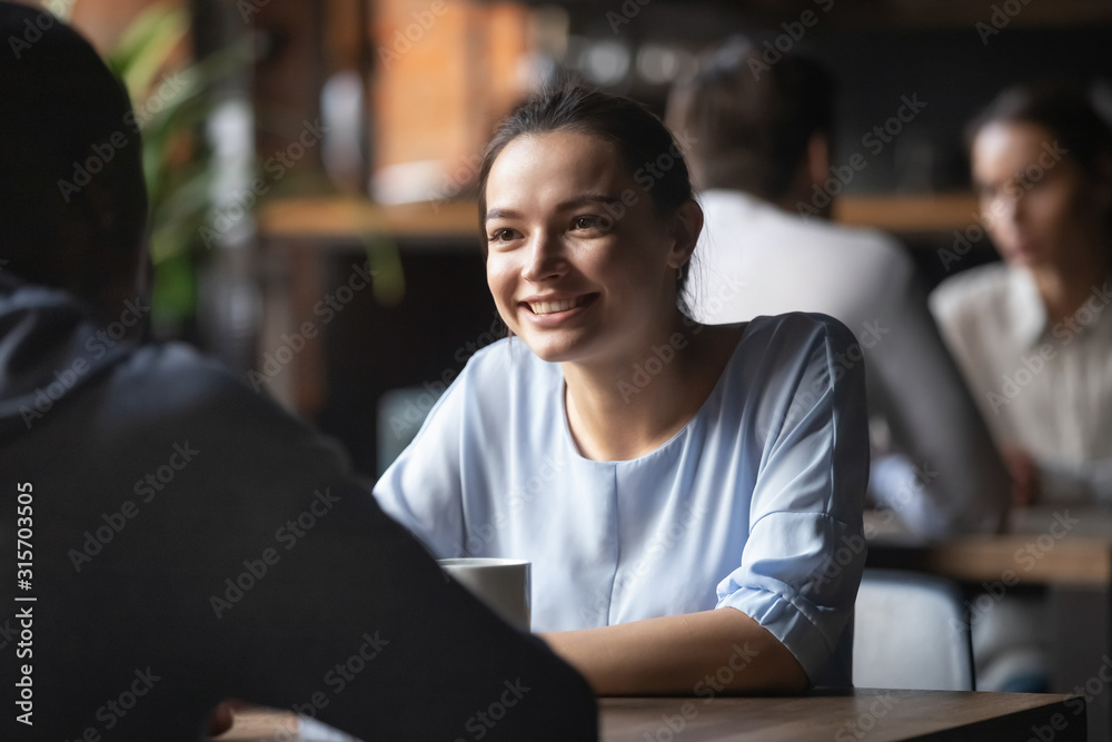 Smiling young woman enjoying pleasant talk on date Smiling young woman enjoying pleasant talk on date