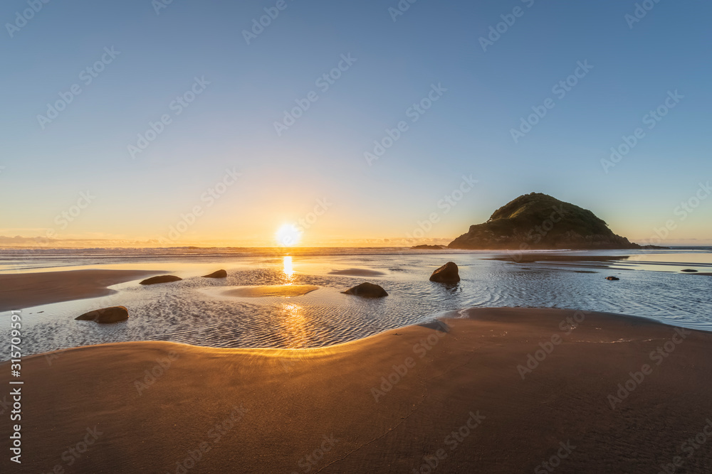New Zealand, Tongaporutu, Clear sky over sandy coastal beach at sunset with Motuotamatea island in background New Zealand, Tongaporutu, Clear sky over sandy coastal beach at sunset with Motuotamatea island in background