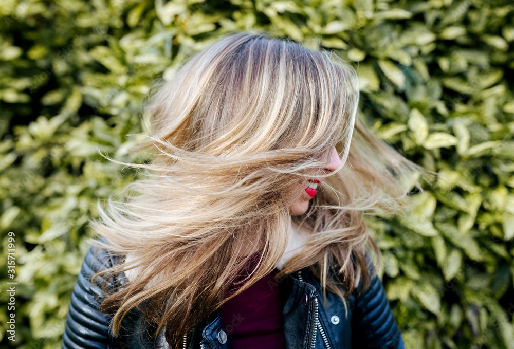 Beautiful blond woman shaking her hair outdoors Beautiful blond woman shaking her hair outdoors