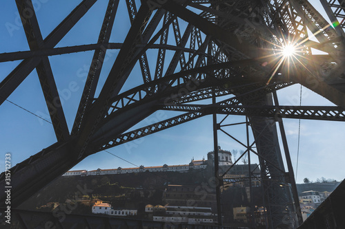 Portugal, Porto District, Porto, Sun shining between iron girders of Dom Luis I Bridge photo