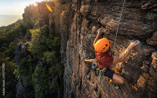 Man climbing Battert rock during sunset