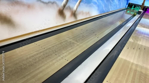 bowling ball rolls and knocks down pins