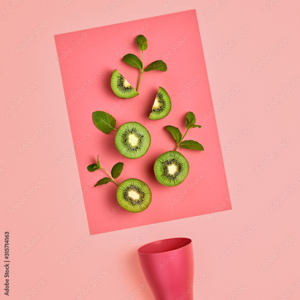 Fototapeta Świeże owoce kiwi z liśćmi mięty. Wegańskie pojęcie zdrowej żywności ekologicznej. kreatywny zielony układ. Leżał płasko. Modny styl mody. Minimalna sztuka Gorące letnie wibracje. Jasny różowy kolor.