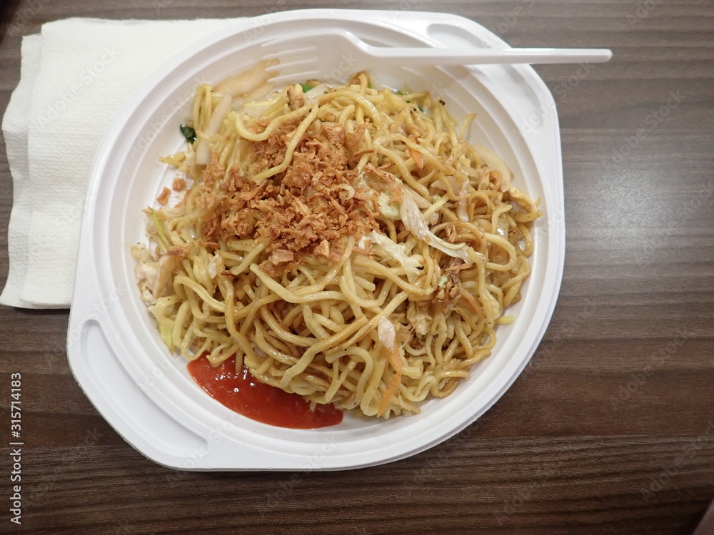 chinese noodles fire with vegetables on a plastic plate chinese noodles fire with vegetables on a plastic plate