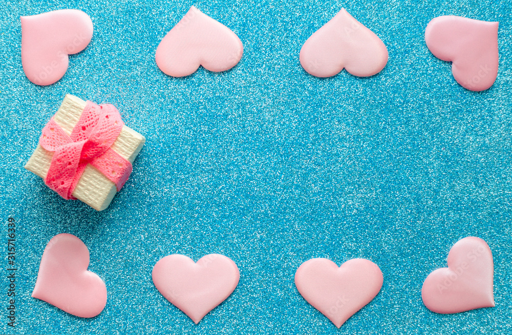Valentines day pattern background flat lay pink hearts and a gold gift box with rose ribbon on a glittering classic blue background with copy space. love wedding romantic concept, minimal top view Valentines day pattern background flat lay pink hearts and a gold gift box with rose ribbon on a glittering classic blue background with copy space. love wedding romantic concept, minimal top view