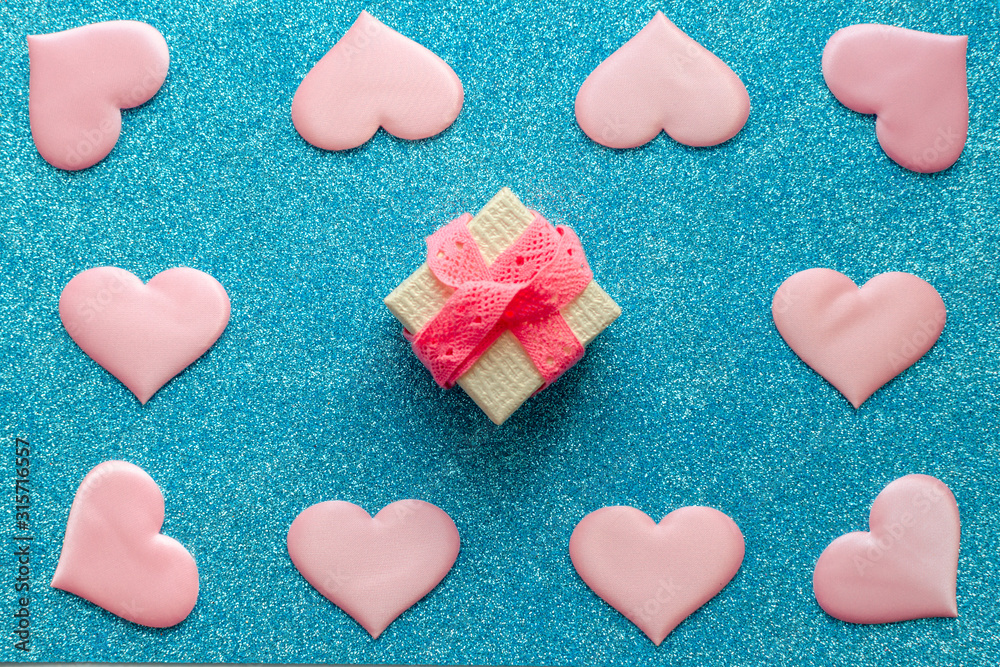Valentines day pattern background flat lay pink hearts and a pink gift box with rose ribbon on a glittering classic blue background with copy space. love wedding romantic concept, minimal top view Valentines day pattern background flat lay pink hearts and a pink gift box with rose ribbon on a glittering classic blue background with copy space. love wedding romantic concept, minimal top view