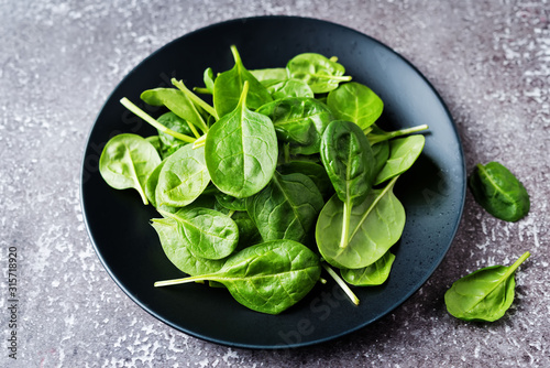 Raw fresh spinach leaves on a stone background