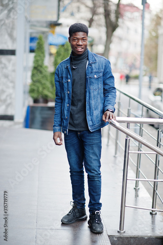 African man wear on jeans jacket posed outdoor.
