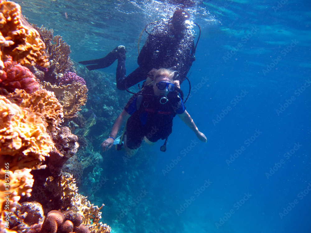 Woman scuba diver and beautiful colorful coral reef underwater