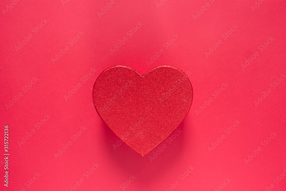 Heart shaped glittered red box isolated on red background. Valentine's day gift box with copy space, mock up.