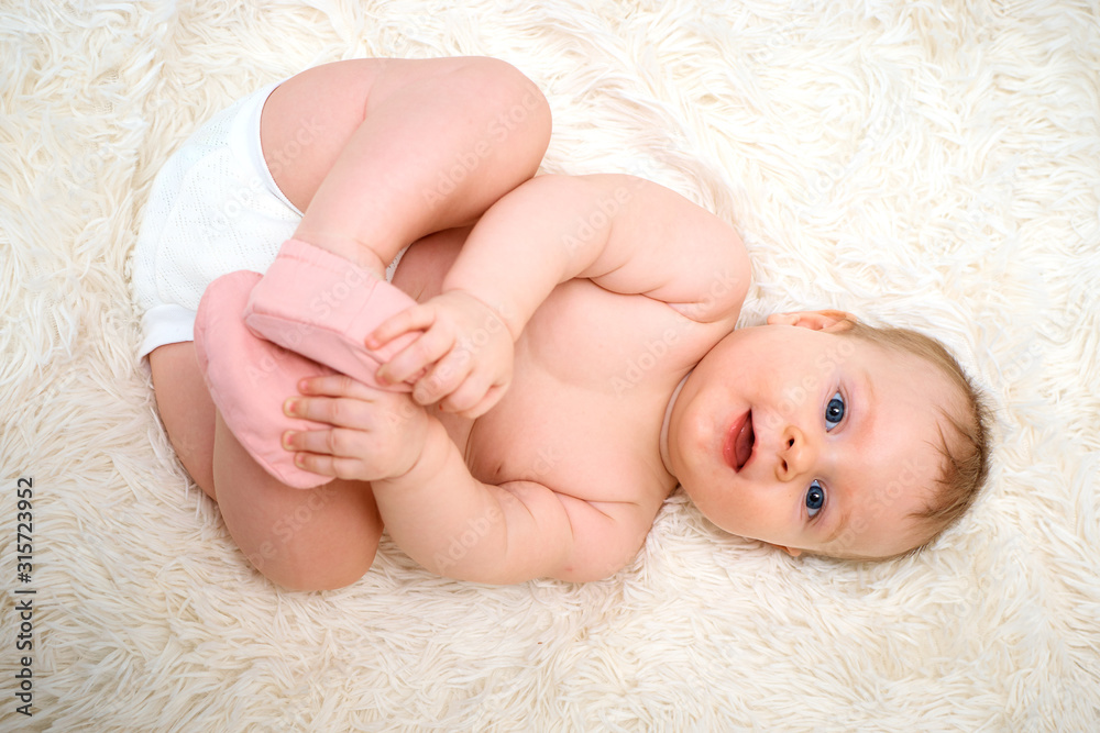 a small child is lying on his back and holding on to the legs a small child is lying on his back and holding on to the legs