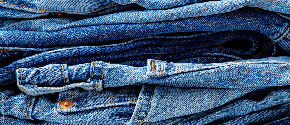 Pile of classic blue jeans. Urban outfit, basic essencial wardrobe, shopping concept Pile of classic blue jeans. Urban outfit, basic essencial wardrobe, shopping concept