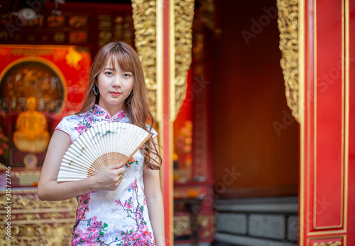 Photography Beautiful young Chinese woman in a Cheongsam dresses or Chinese traditional dresses standing in Chinese Temple