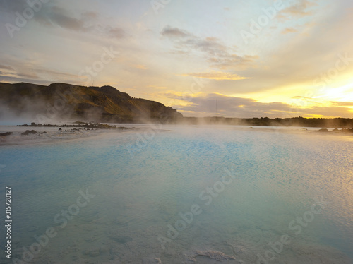 Beautiful landscape of Blue Lagoon thermal bath in Iceland with steam in a cold atmosphere in sunset with a dramatic sky.