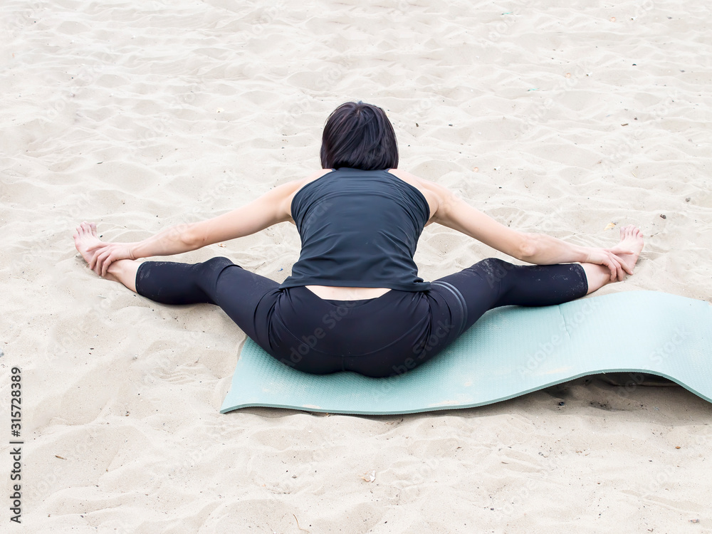Yoga on the beach. Close up, girls on the seashore, on the sand, in the fresh air, doing yoga. Zantia sports, Pilates, stretching in the fresh air.