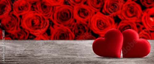 Fototapeta Naklejka Na Ścianę i Meble -  Valentine's day two red silk hearts on rose and  wooden background