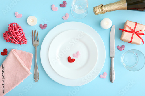 Festive table setting for Valentine's Day with cutlery, gift boxes and hearts on the table. Space for text. View from above.