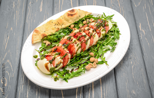 Italian trditional caprese salad with pesto sauce and basil photo