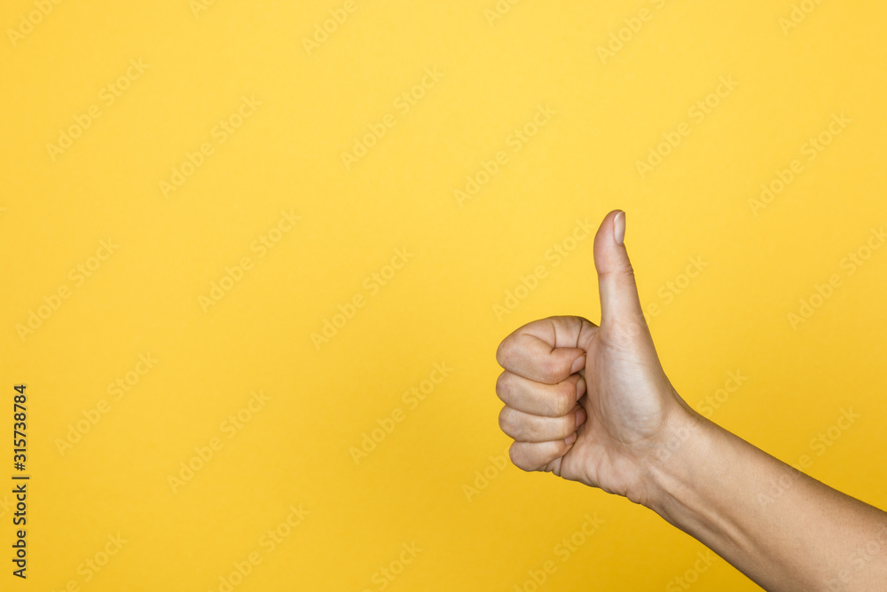 Hand of client show thumb up on yellow background, satisfaction concept, copy space for design