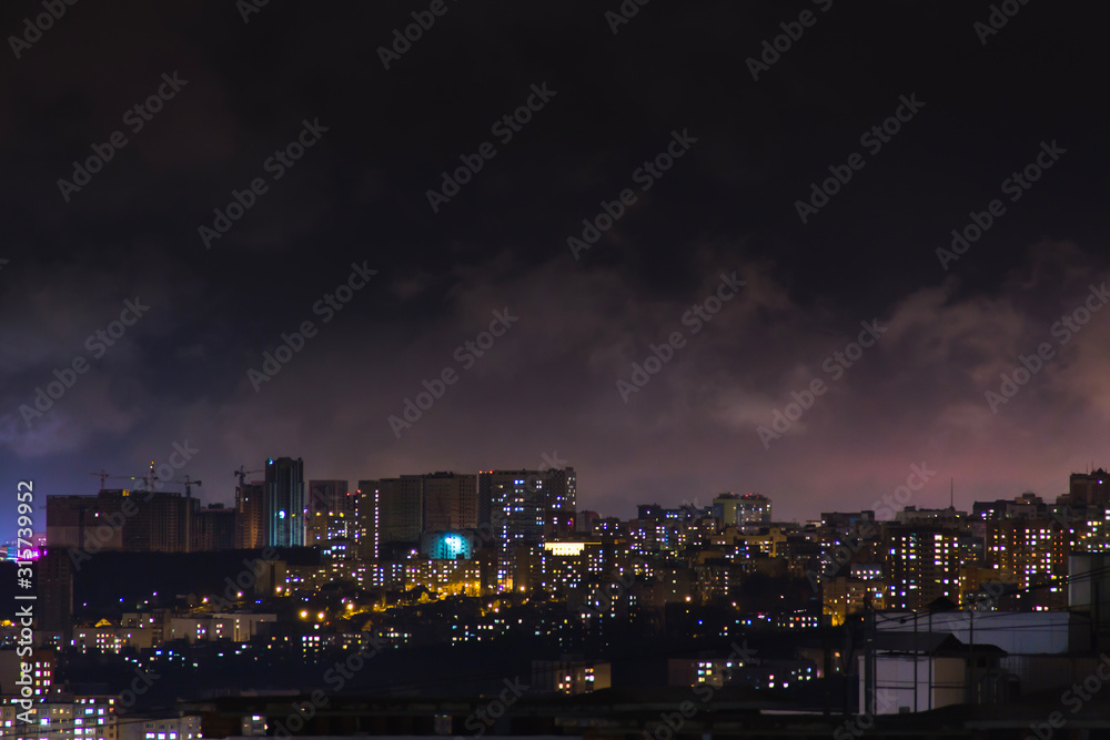 Evening shot of a city on hill buildings.Top aerial panoramic view. Construction cranes on new residential areas