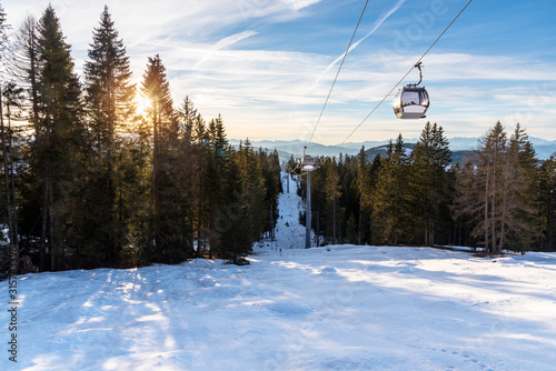 Cable cars in a snowy alpine landscape at sunset
