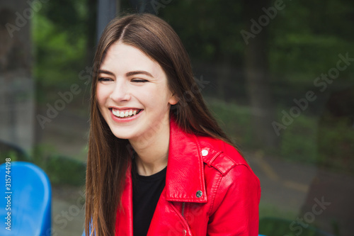Pretty smiling girl in red leather jacket
