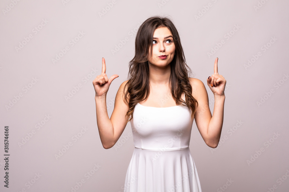 Funny young woman pointing finger up isolated over grey background. Funny young woman pointing finger up isolated over grey background.