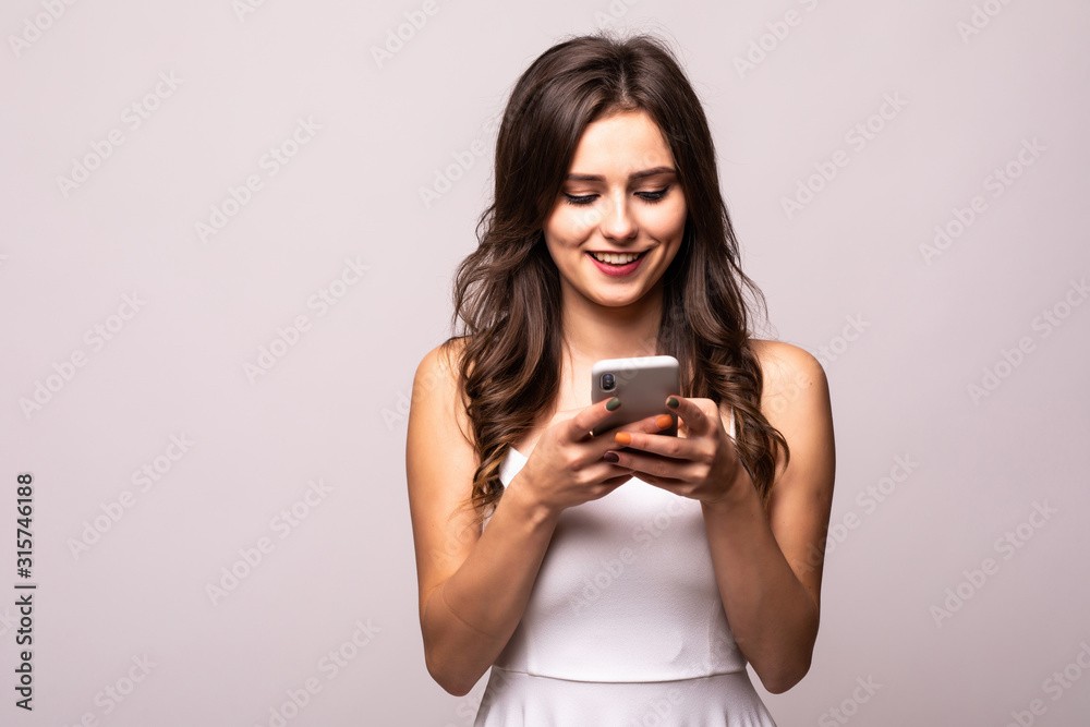Young woman texting on her mobile phone isolated over a white background Young woman texting on her mobile phone isolated over a white background