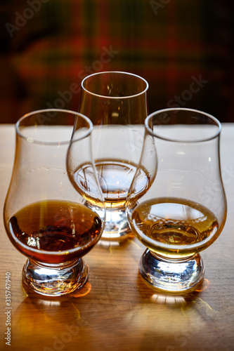 Scotch whisky, tasting glasses with variety of single malts or blended whiskey spirits on distillery tour in Scotland © barmalini