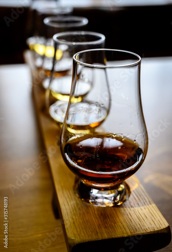 Scotch whisky, tasting glasses with variety of single malts or blended whiskey spirits on distillery tour in Scotland