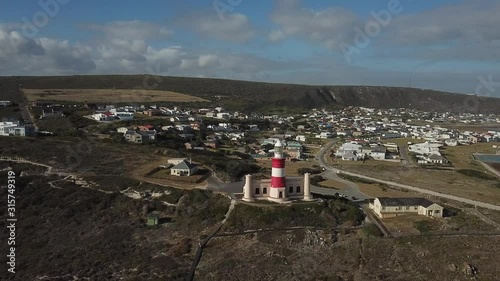 4K sunny summer aerial drone video of Cape Agulhas Lighthouse on southernmost tip of African continent peninsula near Indian Ocean coastal village L'Agulhas, Garden Route, Western Cape, South Africa