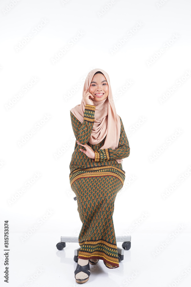 Fototapeta premium Female student in various poses wearing modern kurung, a modern urban lifestyle apparel for Muslim women isolated on white background. Beauty and hijab fashion concept.