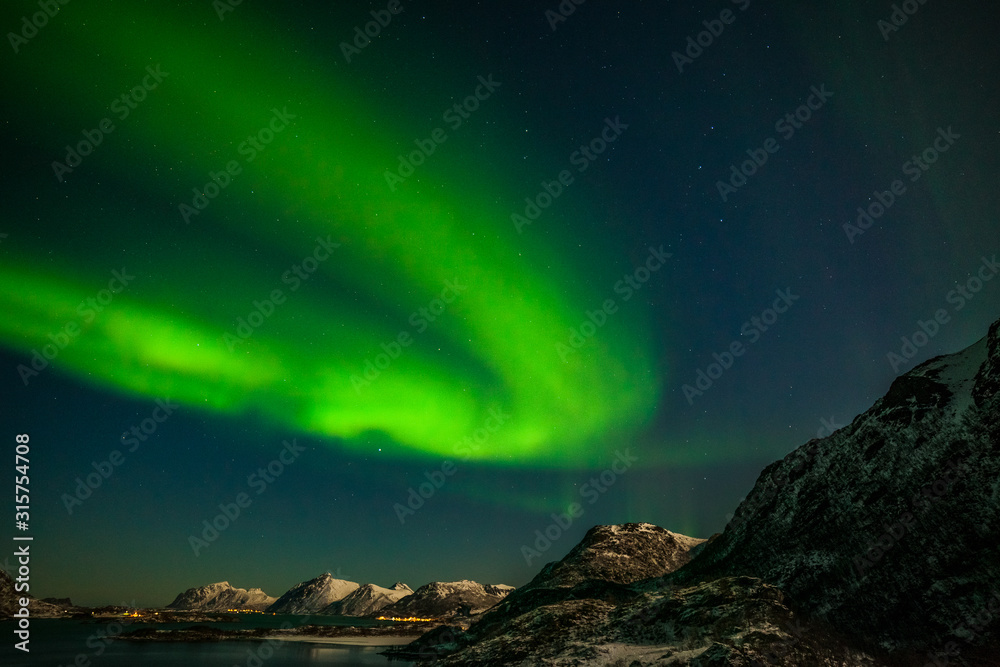 amazing northern lights, aurora borealis over the mountains in the North of Europe - Lofoten islands, Norway