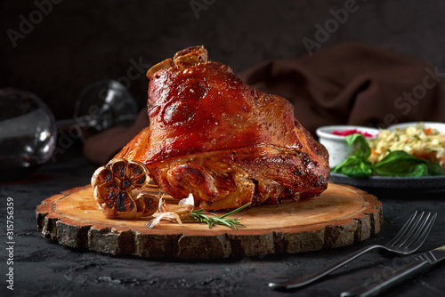 Roasted pork knuckle eisbein with cabbage and mustard on wooden cutting board photo