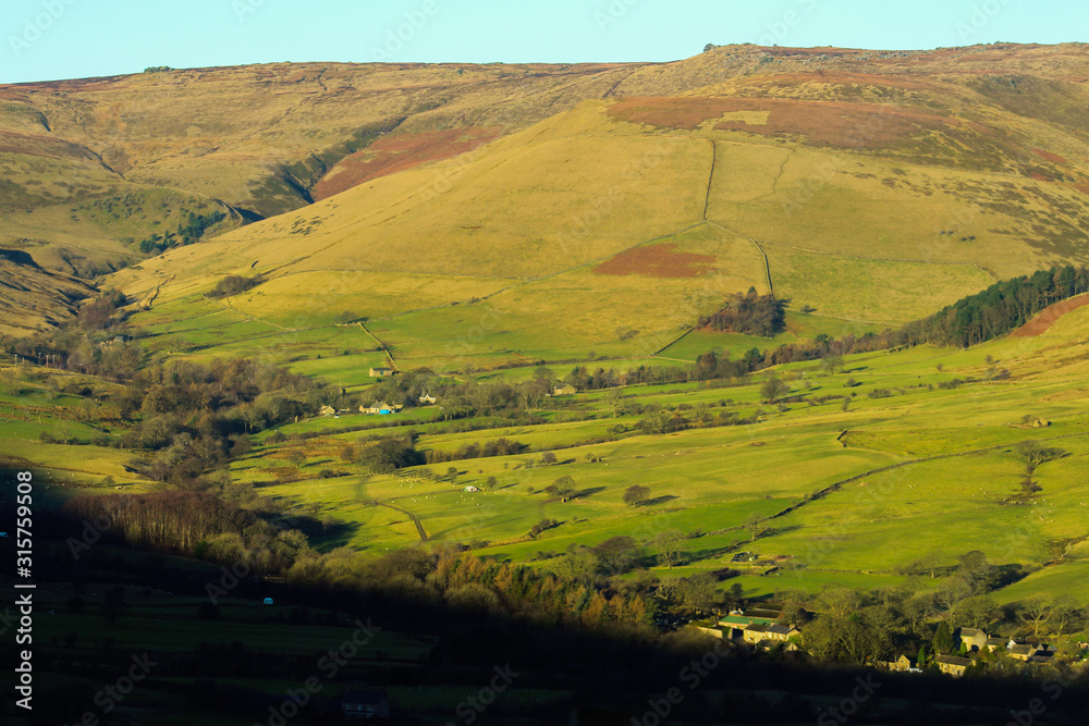 green valley with farms in the mountains