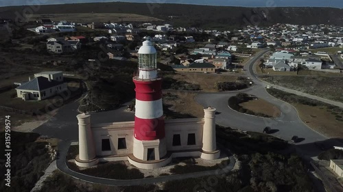 4K sunny summer aerial drone video of Cape Agulhas Lighthouse on southernmost tip of African continent peninsula near Indian Ocean coastal village L'Agulhas, Garden Route, Western Cape, South Africa