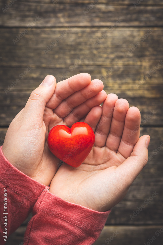 Child hold a red heart in their hands. Child hold a red heart in their hands.