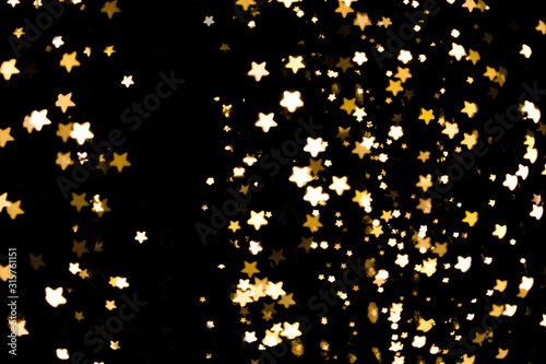 Festive overlay effect. Golden stars bokeh festive glitter dark background with copy space. Christmas, New Year, holidays and any other any purposes design.