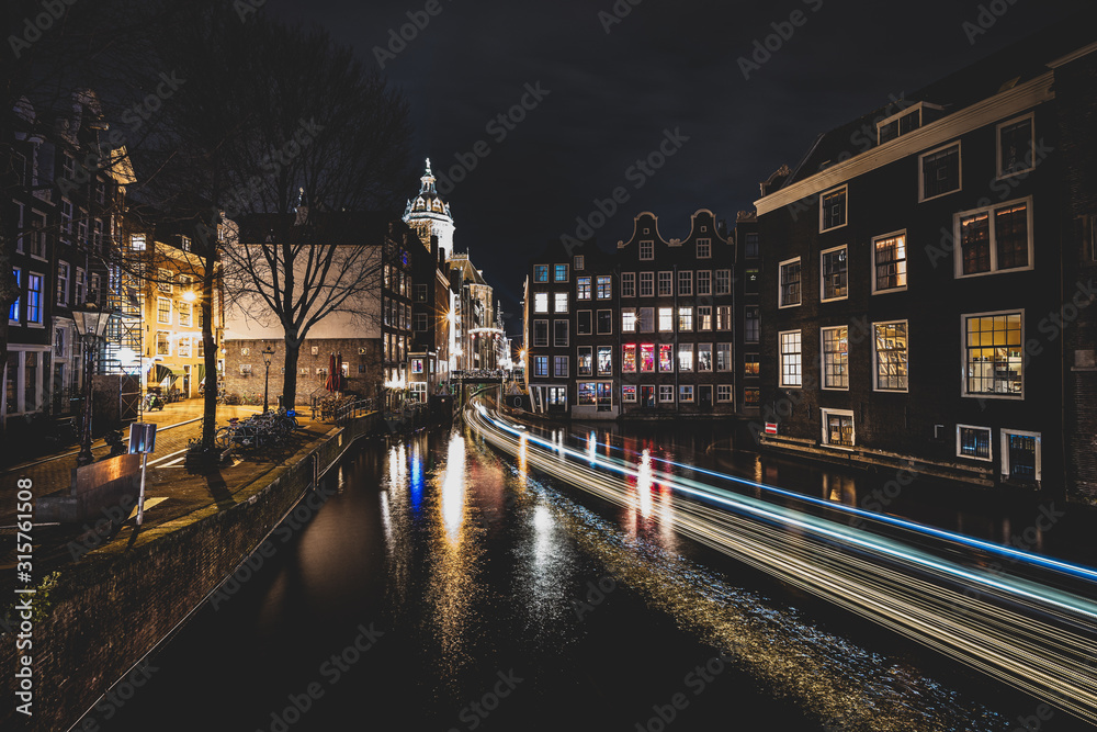 Amsterdam canals and houses against night cityscape of Amsterdam, Holland Netherlands