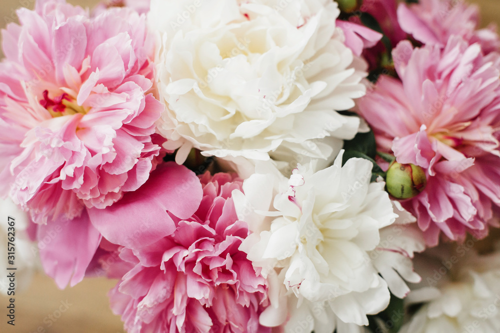 Happy Mothers day greeting card. Beautiful peony bouquet in sunny light. Stylish pink and white peonies on wooden background. Hello spring. Happy valentines day Happy Mothers day greeting card. Beautiful peony bouquet in sunny light. Stylish pink and white peonies on wooden background. Hello spring. Happy valentines day