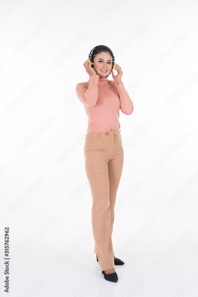 Cheerful Asian teenager wearing turtleneck and pants using wireless headphones enjoying listening to music studio portrait shot isolated on white background. Easy to cut out. Portrait orientation. Cheerful Asian teenager wearing turtleneck and pants using wireless headphones enjoying listening to music studio portrait shot isolated on white background. Easy to cut out. Portrait orientation.