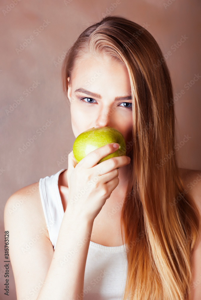 young pretty blond woman holding green apple smiling slim, lifestyle people concept young pretty blond woman holding green apple smiling slim, lifestyle people concept