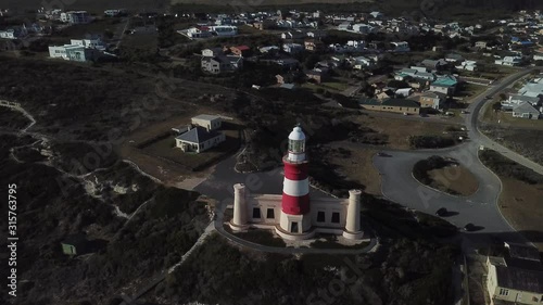 4K sunny summer aerial drone video of Cape Agulhas Lighthouse on southernmost tip of African continent peninsula near Indian Ocean coastal village L'Agulhas, Garden Route, Western Cape, South Africa